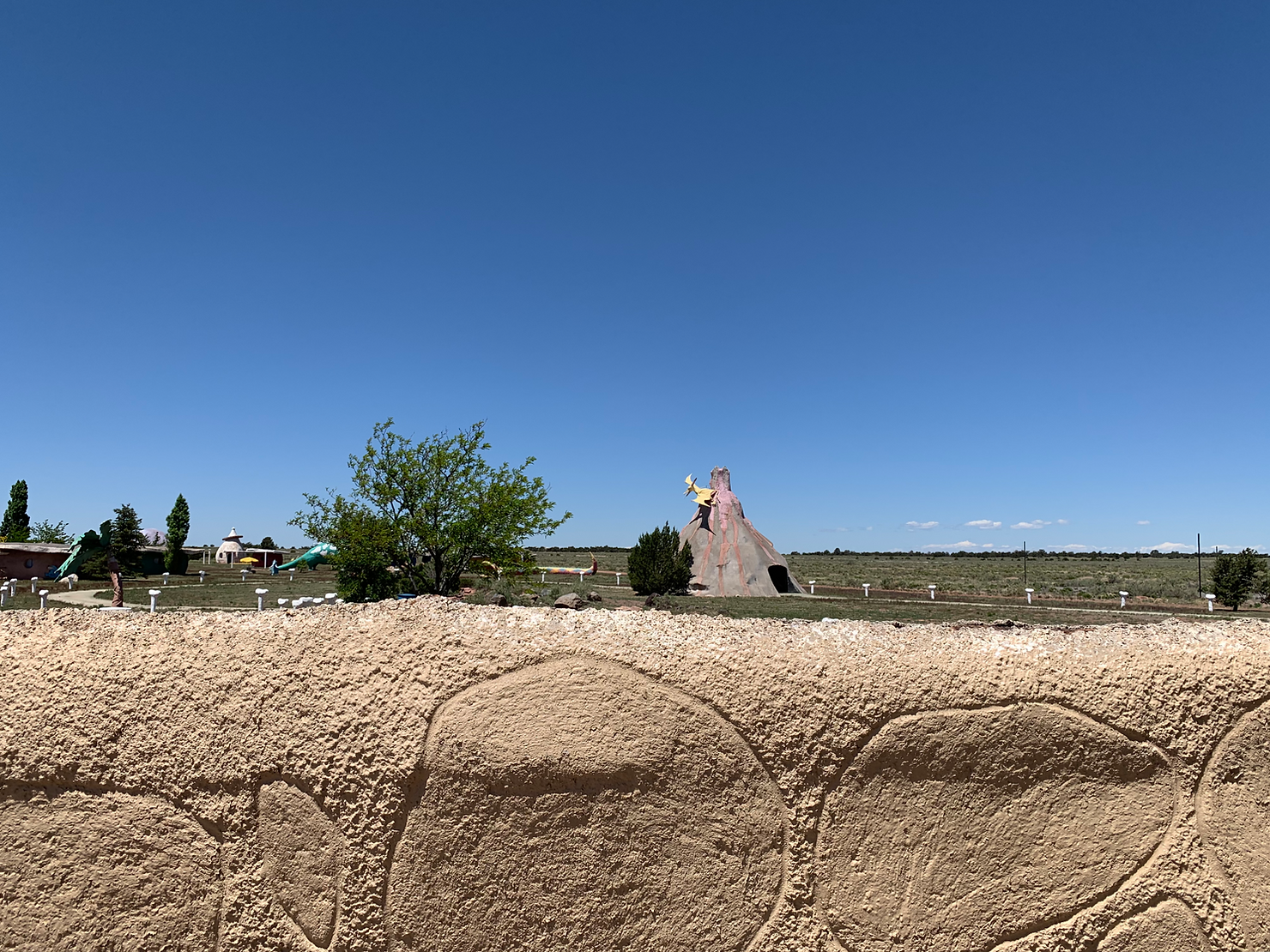 Look over the fence at the volcano Bedrock City in Arizona, Raptor Ranch